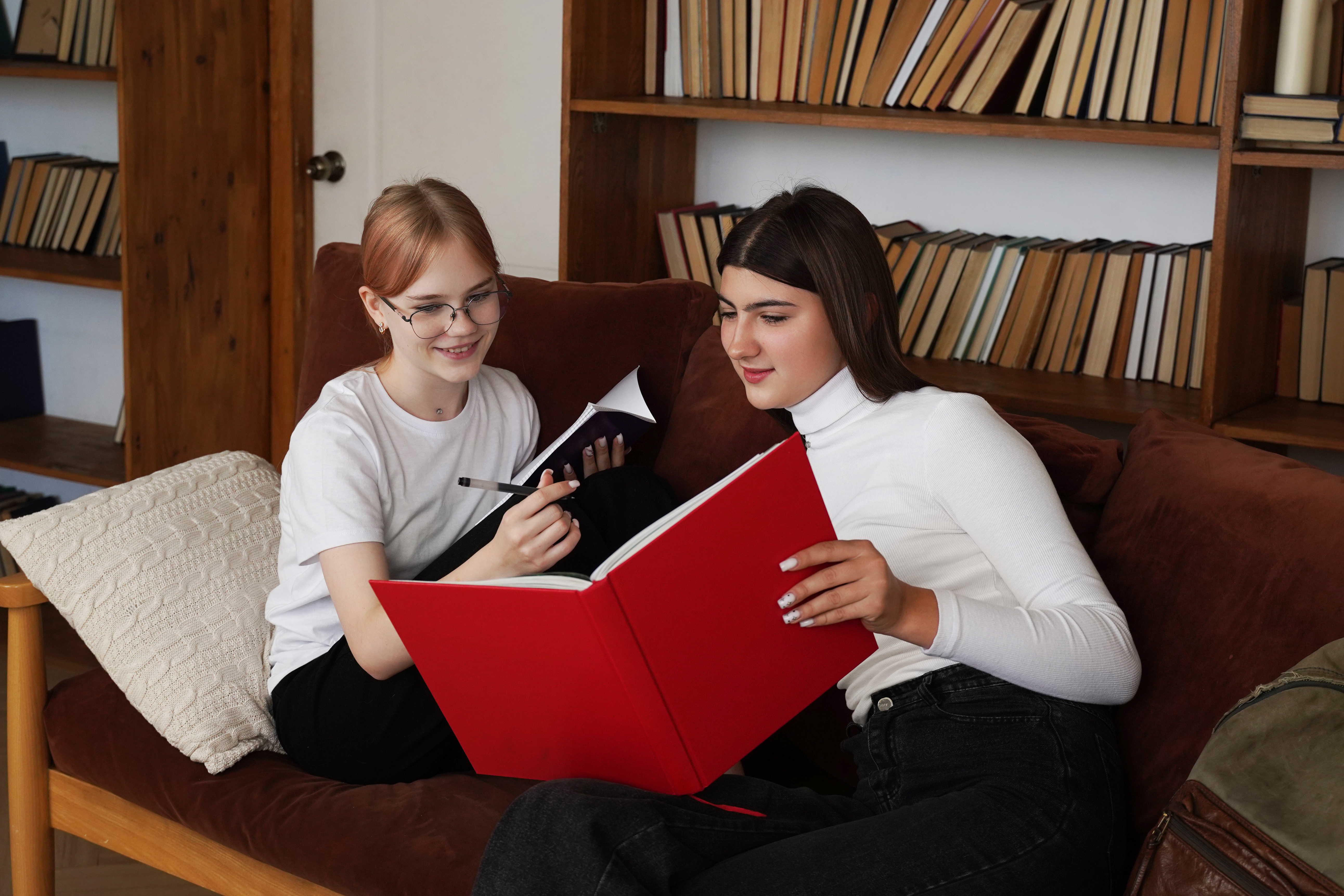 Zwei junge Frauen blättern in Büchern.