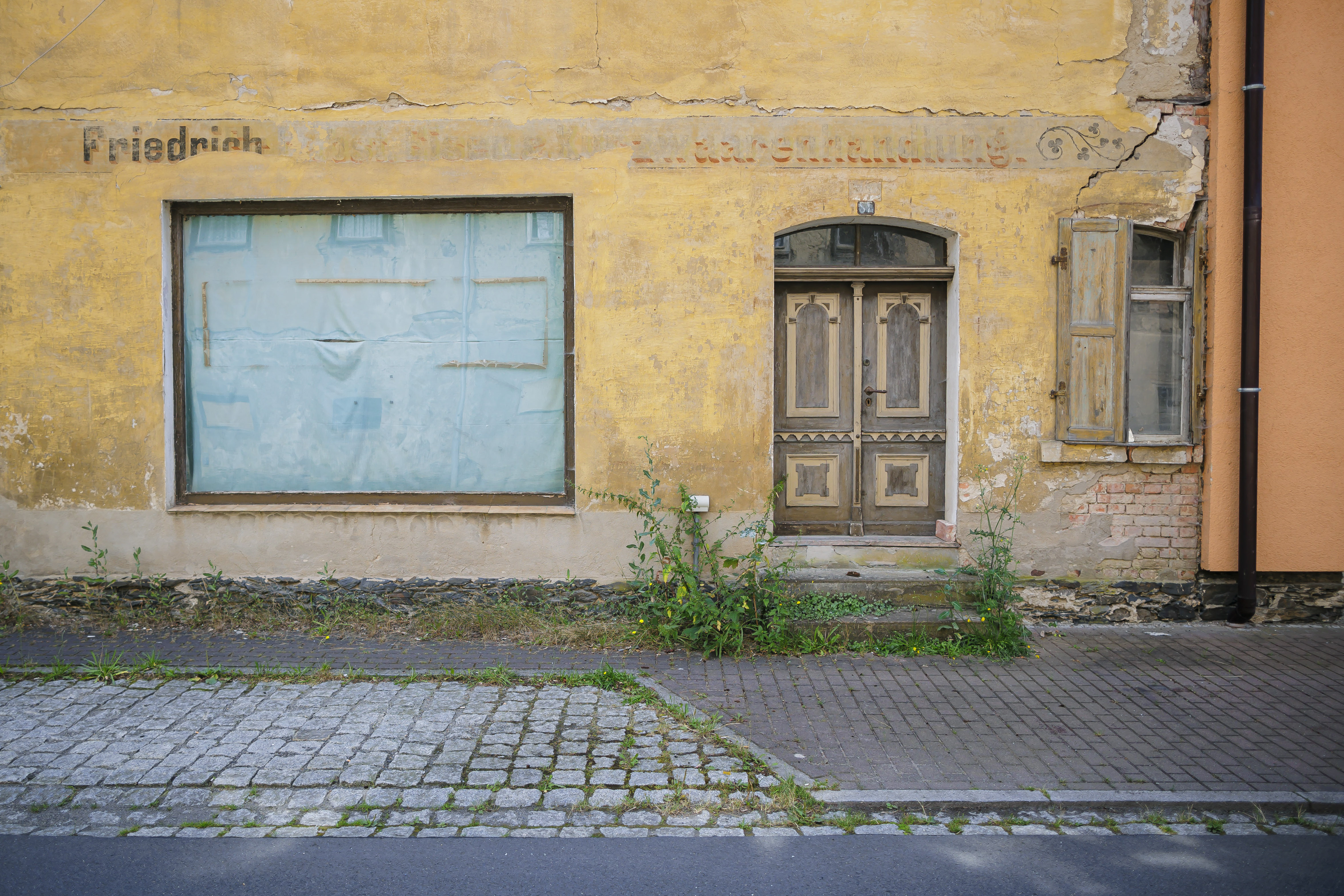 Hausfassade mit zugeklebtem Schaufenster