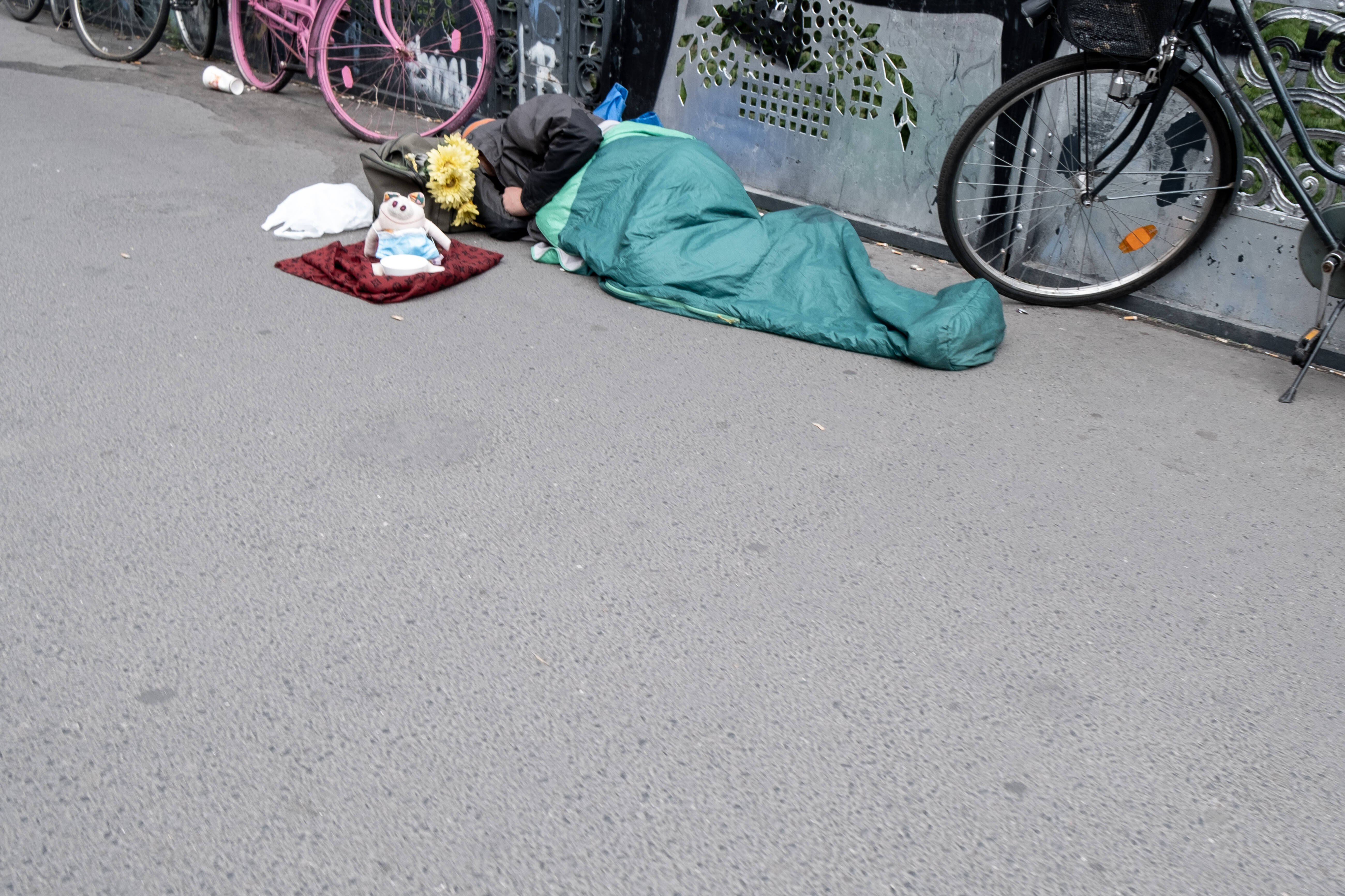 Obdachloser Mensch im Schlafsack auf der Straße