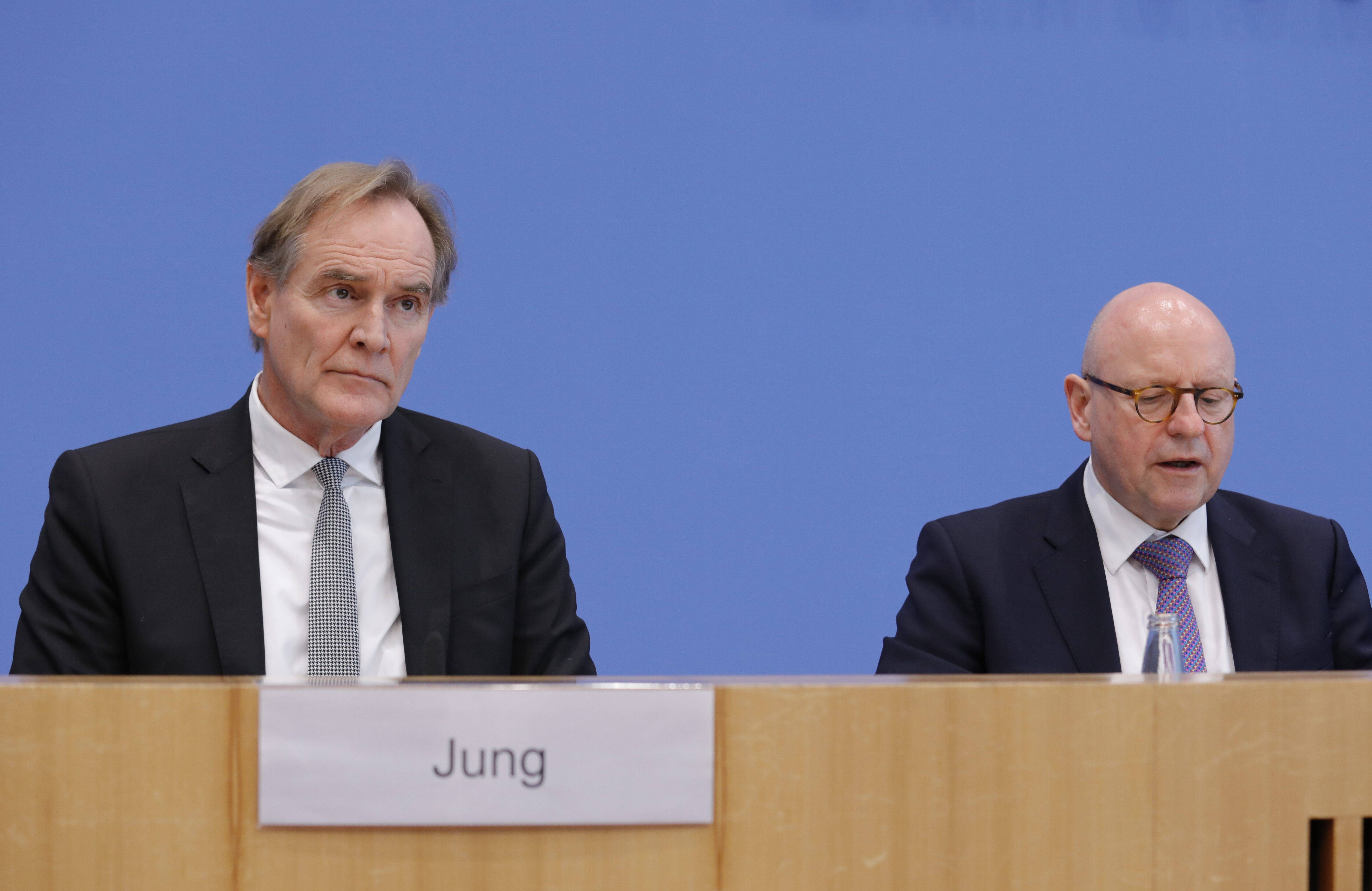 Burkhard Jung und Markus Lewe sitzen auf dem Podium der Bundespressekonferenz vor einer blauen Wand